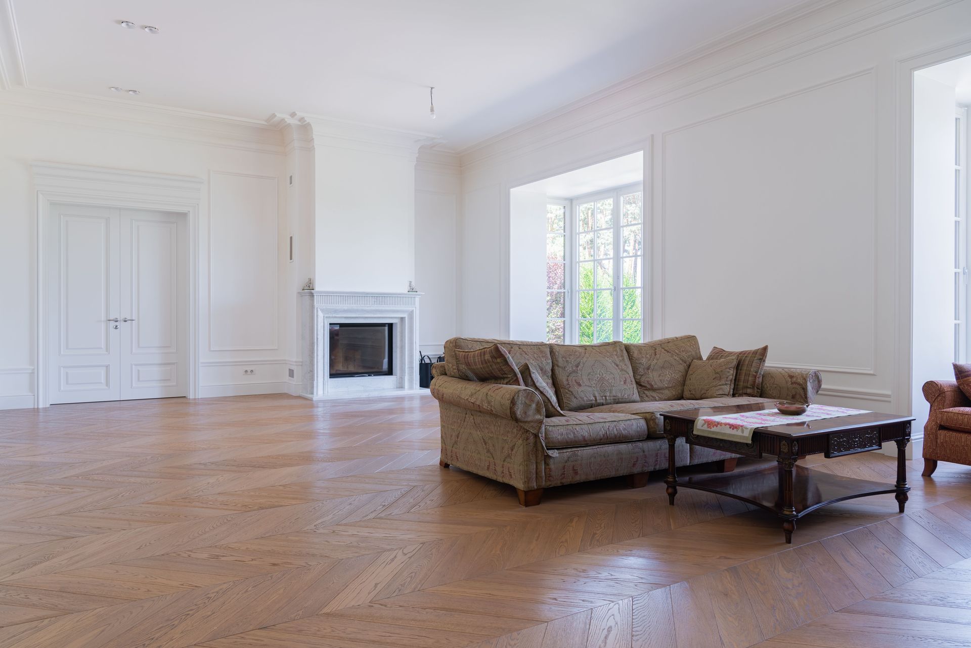 Beautiful spacious living room featuring elegant modern furniture and hardwood floors.